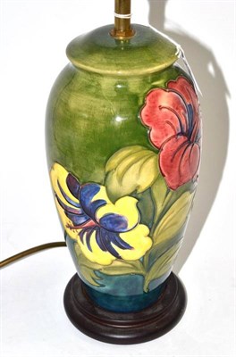 Lot 167 - A Walter Moorcroft hibiscus pattern lamp, on a green ground, 28cm