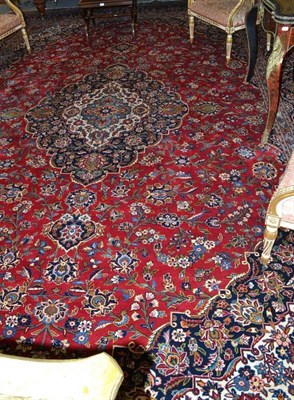 Lot 1117 - Kashan Carpet  Central Persia The blood red field of scrolling vines around an indigo pole...