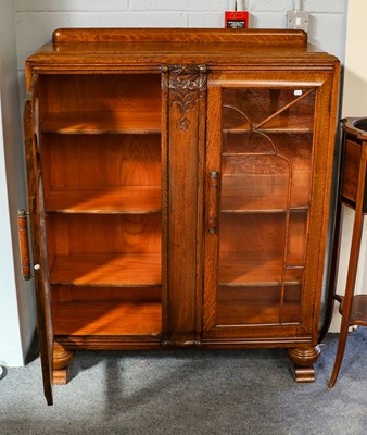 Lot 1204 - A 1940's carved oak display cabinet raised on...