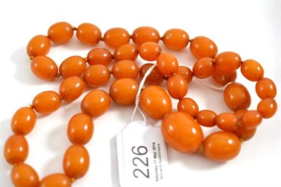 Lot 226 - A graduated strand of amber-type beads