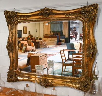 Lot 1103 - A large reproduction gilt mirror, the bevelled...