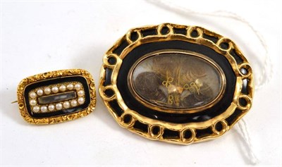 Lot 324 - A black enamelled mourning brooch with locket enclosing three locks of hair, engraved to the...