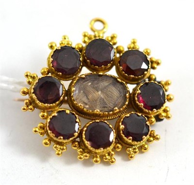 Lot 332 - A garnet mourning brooch, the round garnets surround a locket enclosing plaited hair, within an...