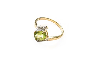 Lot 365 - A 9 carat gold peridot and diamond ring,...