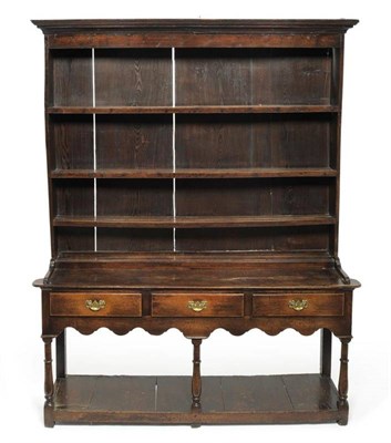 Lot 1135 - An 18th Century Enclosed Dresser, with three fixed shelves and three drawers below above a wavy...