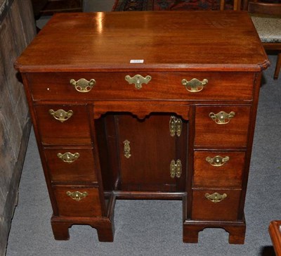 Lot 1143 - A George III Mahogany Kneehole Desk, 18th century and later, the moulded top with re-entrant...