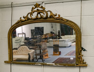 Lot 1228 - A giltwood oval mantel mirror with scrolling...