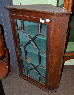 Lot 507 - A Georgian oak glazed hanging corner cupboard