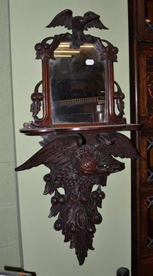 Lot 512 - A 19th century carved mahogany mirror back wall bracket decorated with an eagle