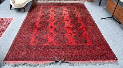 Lot 1006 - An Afghan Turkmen carpet, the faded scarlet...