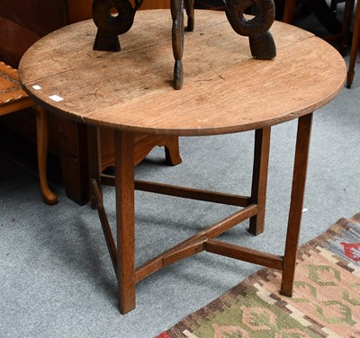 Lot 1125 - An 18th century oak circular drop leaf...