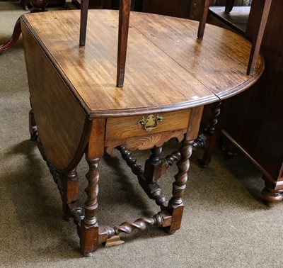 Lot 1202 - An oak gateleg single drawer dining table with...