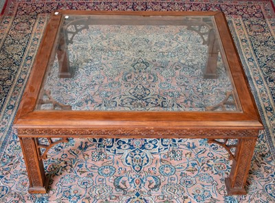 Lot 1140 - A glass top coffee table with blind fret...