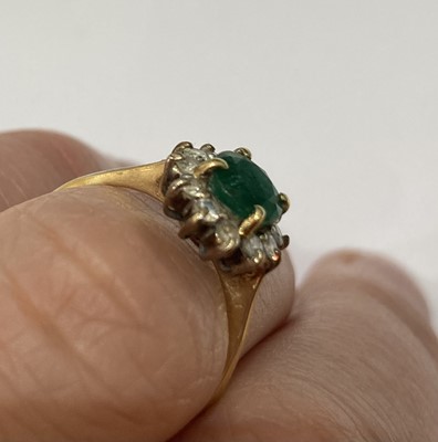 Lot 14 - An emerald and diamond cluster ring, stamped...