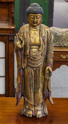 Lot 1171 - A gilt and painted carved wooden standing...