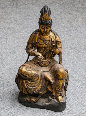 Lot 1173 - A gilt carved wood seated figure of Guan Yin,...