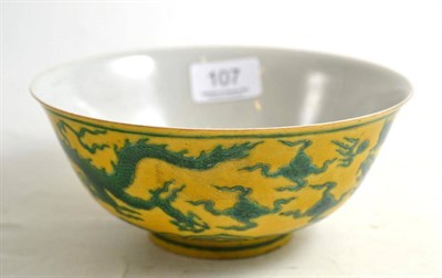 Lot 107 - A Chinese porcelain bowl decorated in green with two duelling five claw dragons on a yellow ground