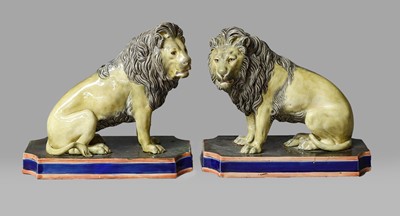 Lot 200 - A pair of majolica models of seated lions,...
