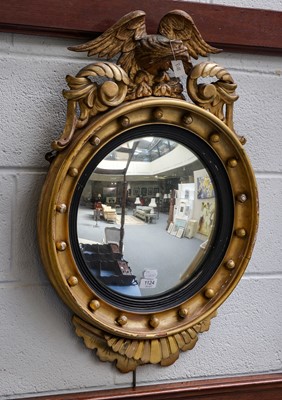 Lot 1124 - A Regency gilt-framed convex mirror with eagle...