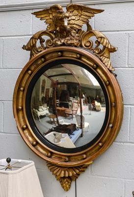 Lot 1123 - A Regency gilt-framed convex mirror with eagle...