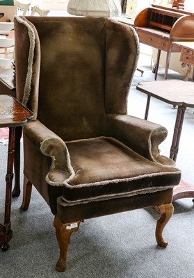 Lot 1155 - A George III style wingback chair on mahogany...