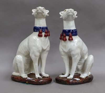 Lot 212 - A pair of faience greyhounds, 36cm high