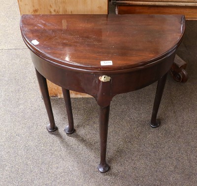 Lot 1274 - A Georgian mahogany fold over demi-lune table,...