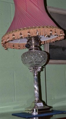 Lot 302 - A silver plated Corinthian column oil lamp with cut glass reservoir and pink shade