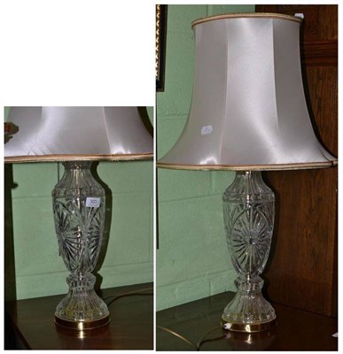 Lot 303 - A pair of cut glass table lamps and shades