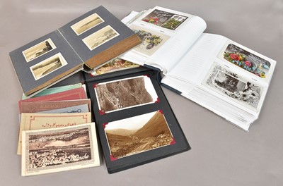 Lot 203 - Three albums of postcards and photographs,...