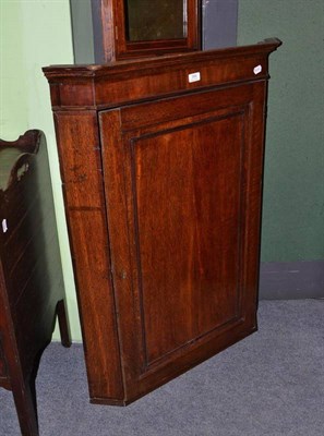 Lot 399 - A George III oak straight fronted wall hanging corner cupboard