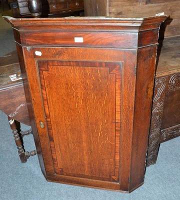 Lot 415 - A Georgian oak straight front hanging corner cupboard