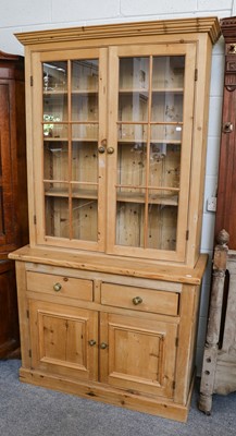 Lot 1132 - A pine bookcase with glazed upper section,...