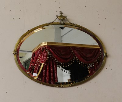 Lot 1089 - An early 20th brass framed oval mirror in the...