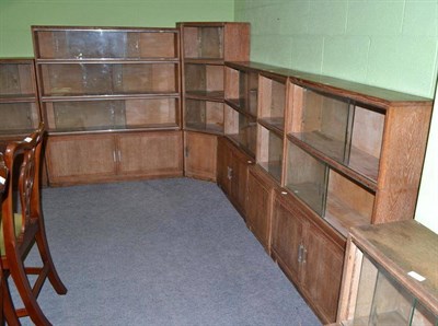 Lot 509 - A set of six limed oak corner bookcases with glazed sliding doors