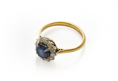 Lot 123 - A sapphire and diamond cluster ring, stamped...