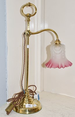 Lot 98 - An Edwardian rise and fall lamp with cranberry...