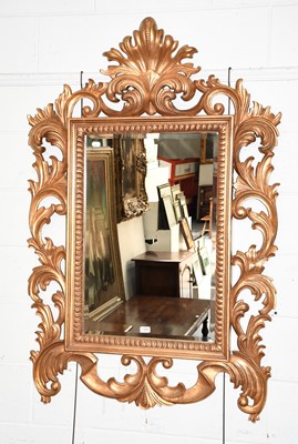 Lot 1306 - A reproduction gilt mirror in wide openwork...