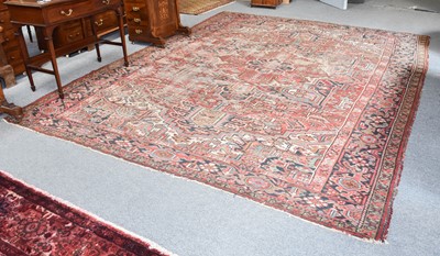 Lot 1197 - Heriz Carpet, the worn madder field of angular...