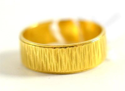 Lot 25 - An 18ct gold patterned wedding band