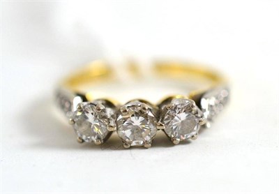 Lot 51 - An 18ct gold diamond three stone ring, with stone set shoulders, total estimated diamond weight...