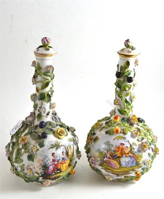 Lot 92 - A pair of Dresden flower-encrusted porcelain bottle vases and covers painted with figures in...
