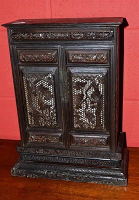 Lot 1263 - A Chinese Zitanwood Miniature Two-Door Cabinet, foliate carved with cupboard doors, interior panels