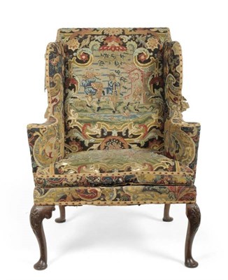 Lot 1267 - An 18th Century Wing-Back Armchair, covered in needlework fabric, with curved armrests and...