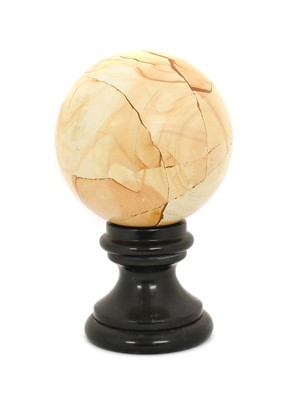 Lot 329 - A Marble Orb, on a circular black slate socle...