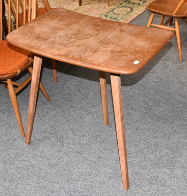 Lot 1349 - A Light Elm Ercol Table, raised on three legs,...