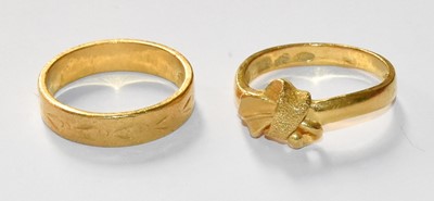 Lot 74 - A Textured Band Ring and A Bow Motif Ring,...