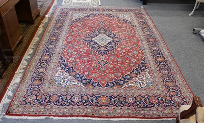 Lot 1229 - A Kashan Carpet, with a blood red field of...