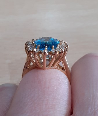 Lot 2029 - A Blue Topaz and Diamond Cluster Ring the oval...