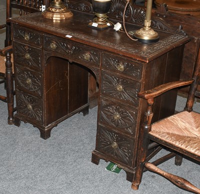 Lot 1175 - An Early 20th Century Carved Oak Kneehole Desk,...